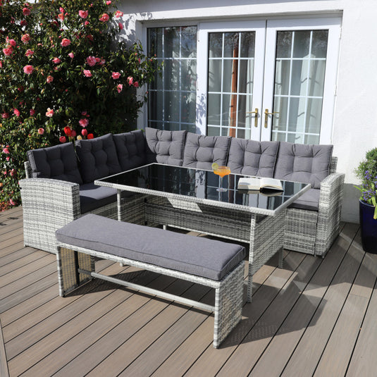 light grey corner sofa set with dark grey cushions, a glass topped rectangular table and 1 bench