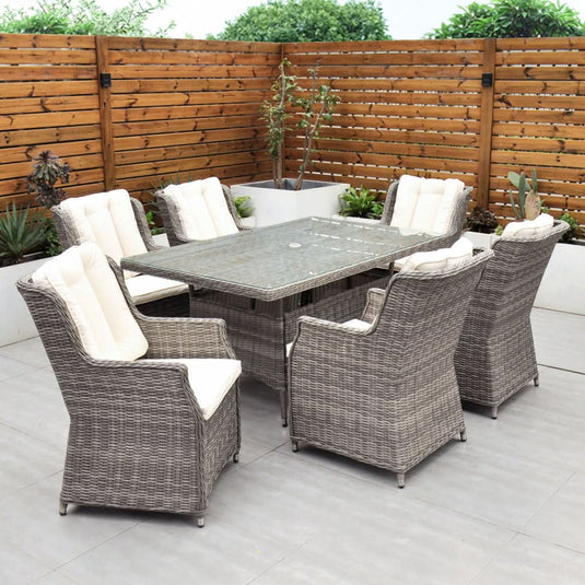 grey 6 seat set with cream cushions and a glass topped rectangular table with a hole for a parasol centrally situated within the table