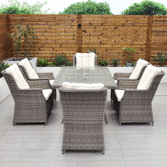 grey 6 seat set with cream cushions and a glass topped rectangular table with a hole for a parasol centrally situated within the table