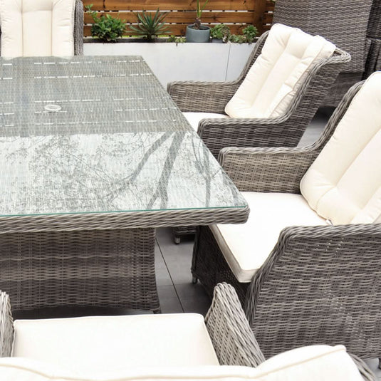 grey 6 seat set with cream cushions and a glass topped rectangular table with a hole for a parasol centrally situated within the table